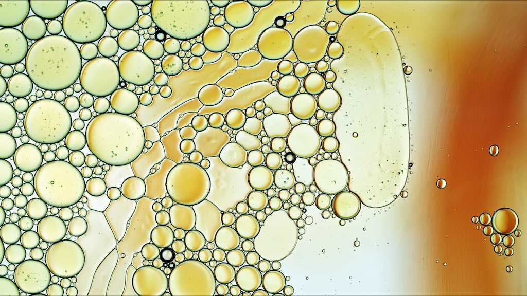Abstract colorful food oil drops bubbles and spheres flowing on water surface