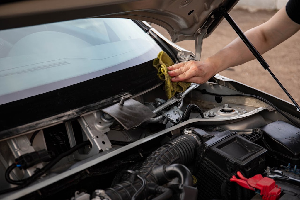 Person wiping windshield using yellow towel