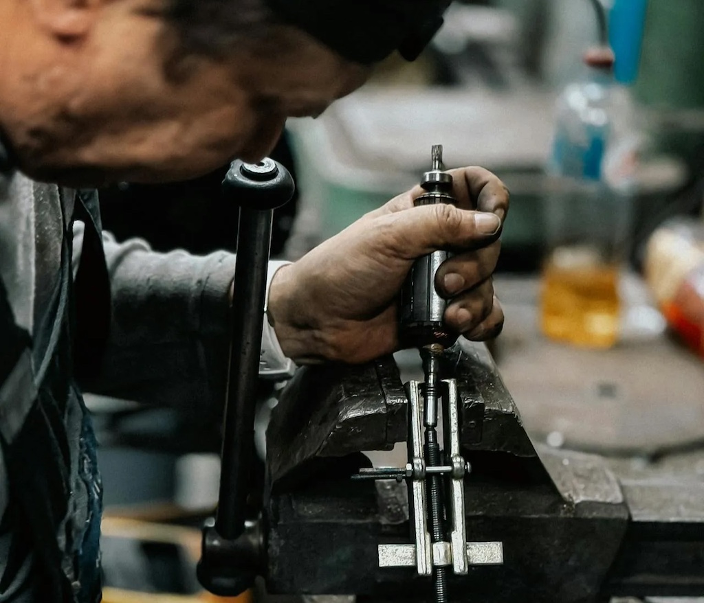 Skilled worker in workshop using power tool