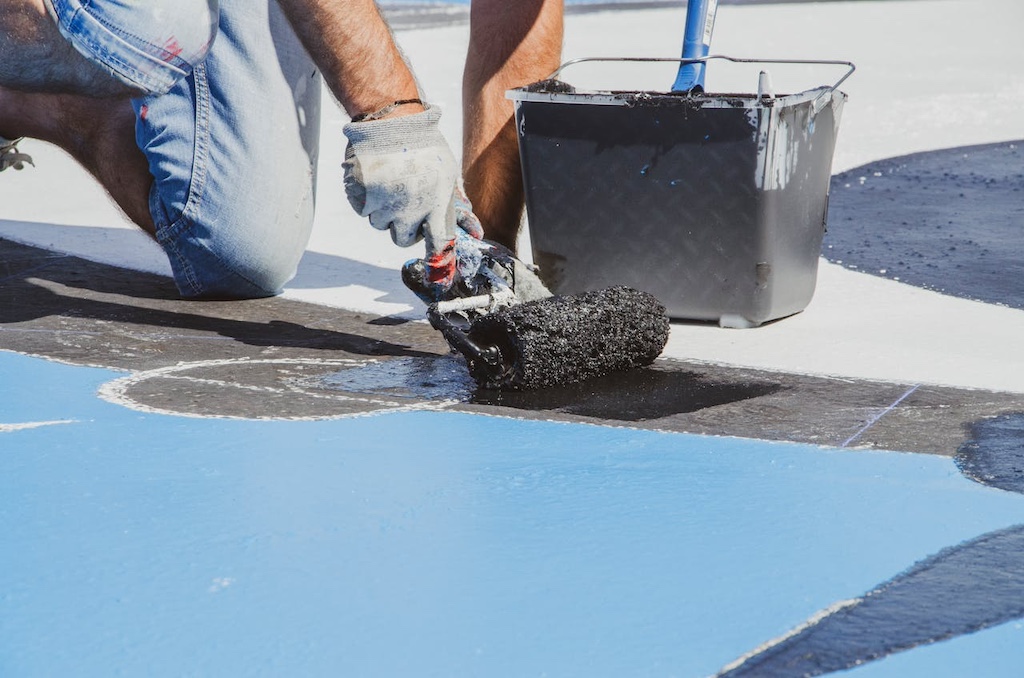 Person with working gloves holding a paint roller