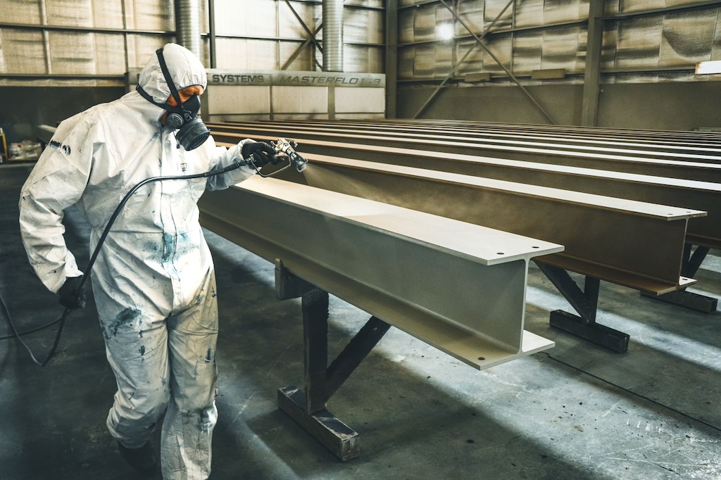 A man painting the metal