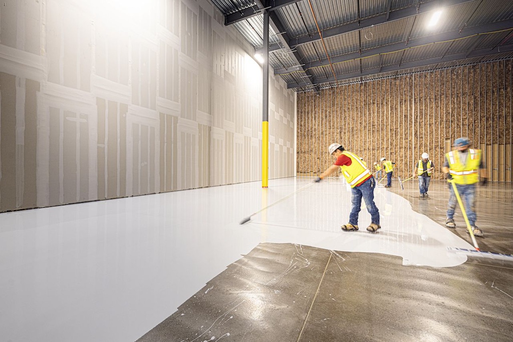 Construction workers laying new concrete floor