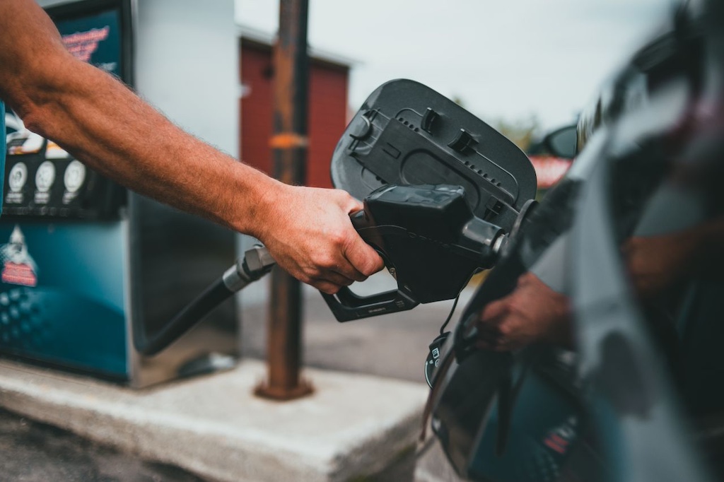 Person putting gasoline on a vehicle