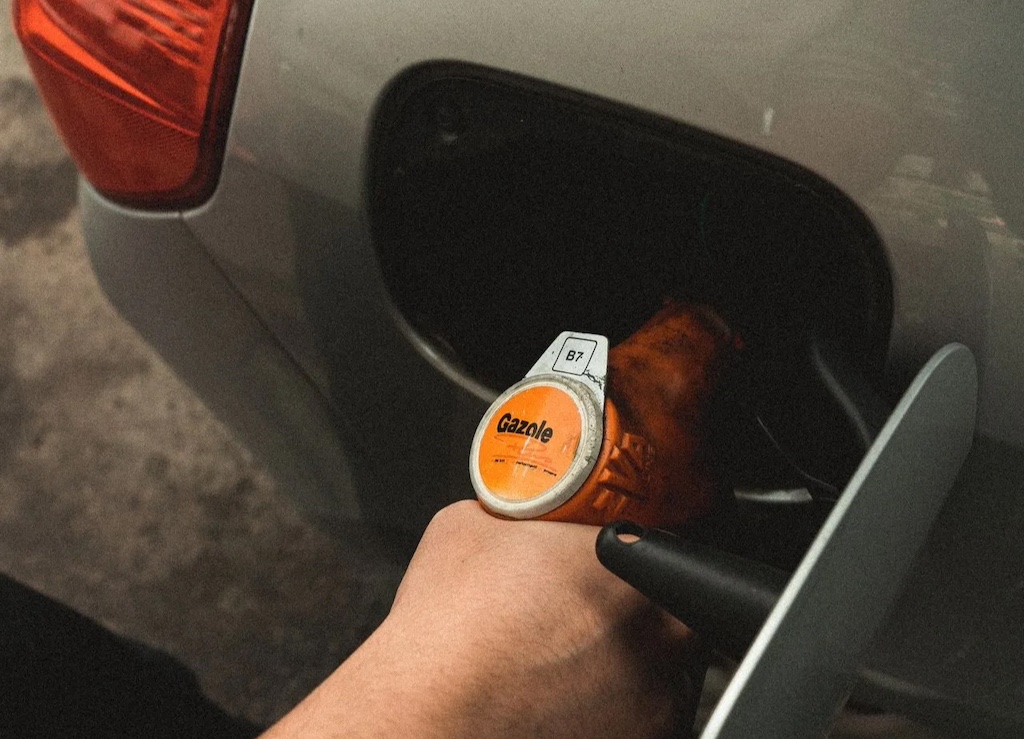 Person refilling gasoline on gas tank